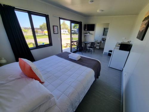 um quarto com uma cama e uma grande janela em Whakatane Holiday Park em Whakatane