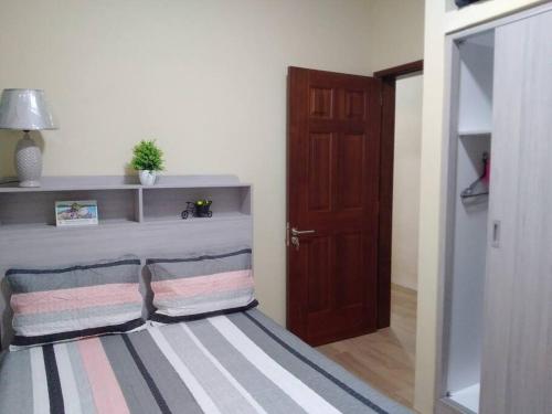 een kamer met een bed met een gestreept tapijt en een deur bij Private home in Flic en Flac - quiet location in Flic-en-Flac