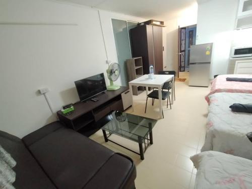 a living room with a couch and a table at ป็อปปูล่าคอนโด เมืองทองธานี ใกล้ Impact 酒店 公寓 in Thung Si Kan