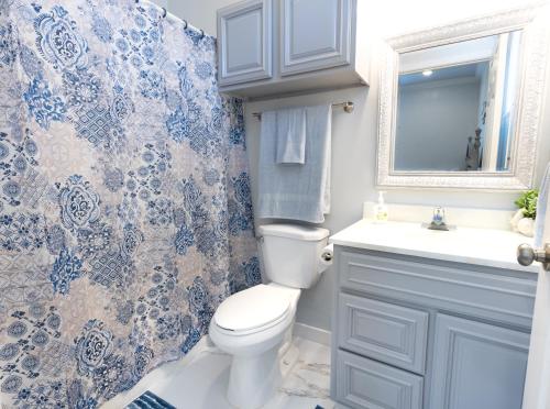 ein Badezimmer mit einem WC, einem Waschbecken und einem Spiegel in der Unterkunft Cozy cottage surrounded by fun in Pass Christian