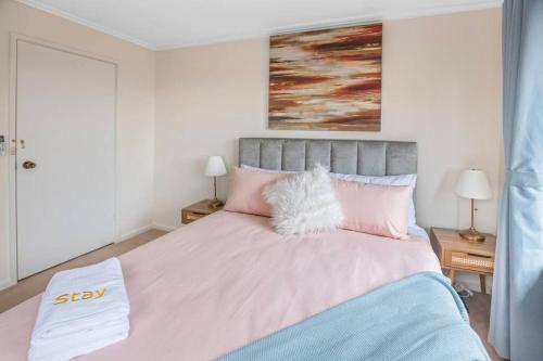 a bedroom with a large bed with pink pillows at Stylish Retreat Family House 5BRM Wheelers Hill in Wheelers Hill