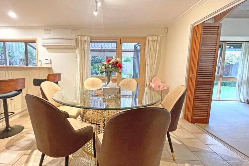a dining room with a glass table and chairs at Stylish Retreat Family House 5BRM Wheelers Hill in Wheelers Hill