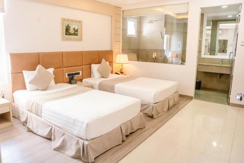 a hotel room with two beds and a bathroom at Holiday One Can Tho Hotel in Can Tho