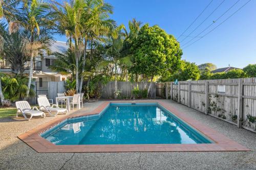a swimming pool in a backyard with a fence at Unit 1 Marcoola Shores in Marcoola