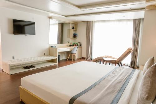 a bedroom with a bed and a desk and a television at Holiday One Can Tho Hotel in Can Tho