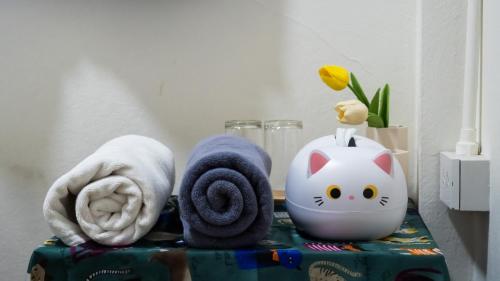 a table with towels and a hello kitty alarm clock at MiuMiu in da house. in Chiang Mai