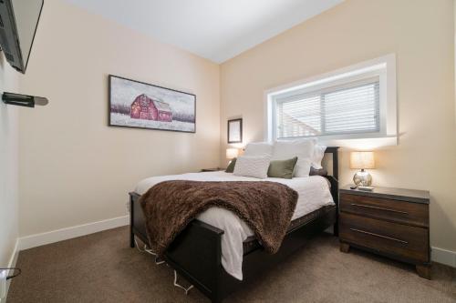 Un dormitorio con una cama grande y una ventana en Oh What A View! - Lower Suite en Vernon