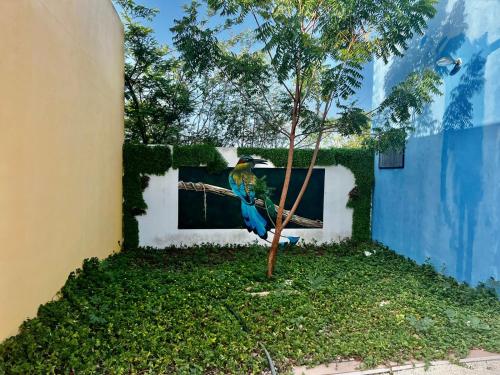 a blue bird sitting on a tree branch next to a building at VILLA DEL CIELO TIXPEHUAL in Tixpehual