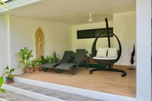a room with two chairs and a swing at Jasmine Village in Rawai Beach