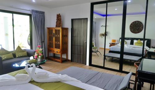 a bedroom with a bed and a living room at Jasmine Village in Rawai Beach
