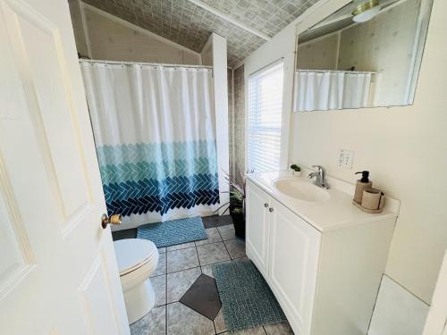 a white bathroom with a toilet and a sink at Alwaves Family 3 Bedroom Beach Apartment in Wildwood