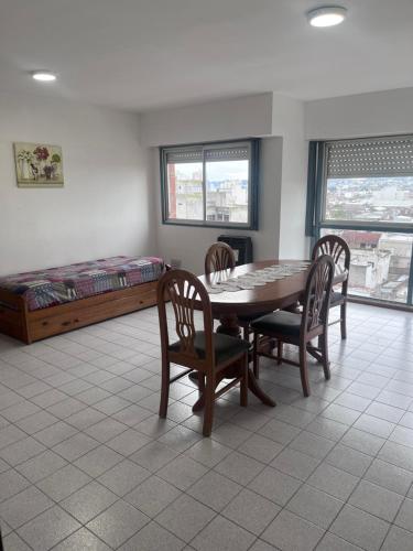 comedor con mesa, sillas y cama en Apartamento Pacifico Delta Suites en Bahía Blanca