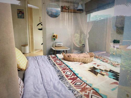 a bedroom with a bed and a table and a window at Phu Morinn Cafe &Camping Monjam in Mon Jam