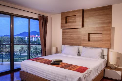 ein Schlafzimmer mit einem großen Bett und einem großen Fenster in der Unterkunft Seastar Hotel and Service Apartment in Ban Chang