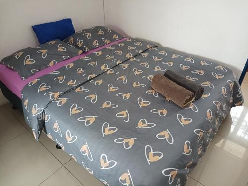 a bed with a gray comforter with a towel on it at Mishra Residence in Suva
