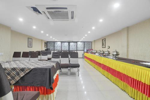 a room with tables and chairs and a pool table at Super Townhouse Divya Palace in Indore