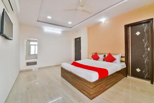 a bedroom with a large bed with red pillows at OYO Flagship 61373 Hotel Paradise in Chittaurgarh