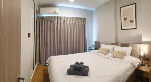 a bedroom with a large white bed with two towels on it at The Astra Sky River Chiangmai_Sky pool_Old City in Chiang Mai