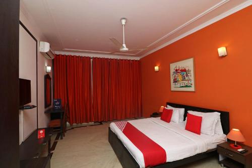 ein Hotelzimmer mit einem Bett mit roten Wänden in der Unterkunft Flagship RK Residency in Sohāna