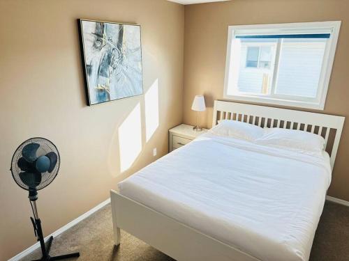 a bedroom with a bed and a fan and a window at Comfortable 6 bedrooms house in Hinton
