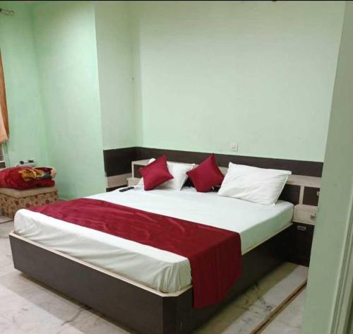 ein Schlafzimmer mit einem großen Bett mit roten und weißen Kissen in der Unterkunft OYO The Blue Sky Hotel And Resort in Gwalior