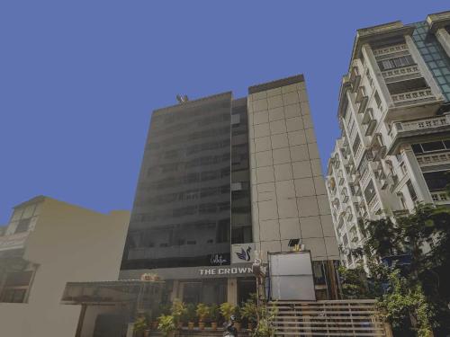 a tall building with a sign in front of it at Collection O THE CROWN HOTEL in Hyderabad