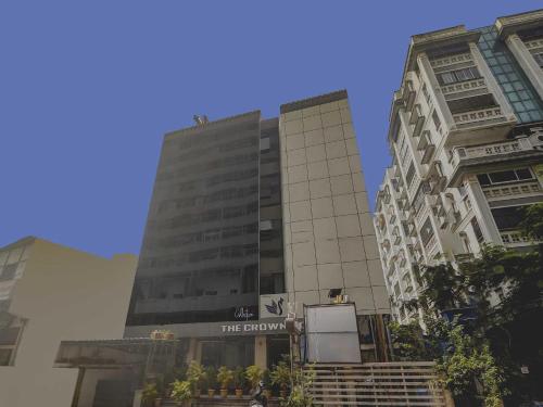 a tall building with a sign in front of it at Collection O THE CROWN HOTEL in Hyderabad