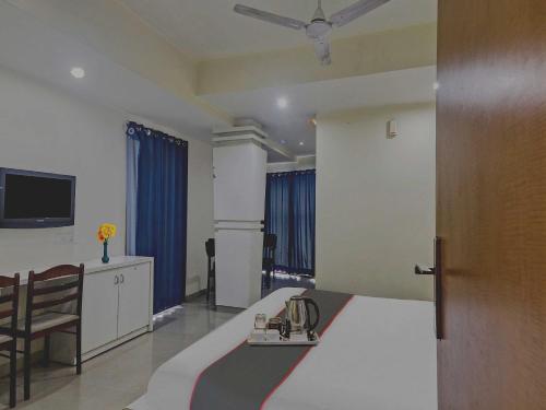 a hotel room with a bed and a television at Collection O THE CROWN HOTEL in Hyderabad