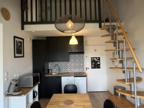 - une cuisine avec une table et un escalier dans une chambre dans l'établissement Accès direct plage, T3 mezzanine, 4 pers, balcon, parking, proche thalasso à Cabourg - FR-1-487-357, à Cabourg