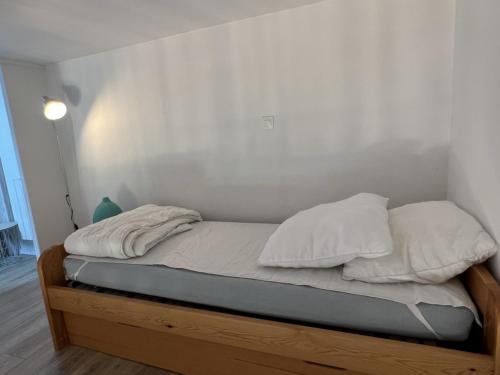 un lit avec deux oreillers dessus dans une chambre dans l'établissement Accès direct plage, T3 mezzanine, 4 pers, balcon, parking, proche thalasso à Cabourg - FR-1-487-357, à Cabourg