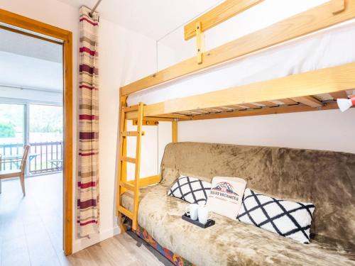 a bedroom with a bunk bed and a couch at Charmant T3 centre de Saint Lary Soulan pour 11 personnes - FR-1-296-469 in Saint-Lary-Soulan
