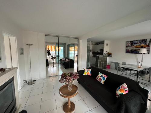 un salon avec un canapé noir et une table dans l'établissement Appartement T3 Front de Mer avec Terrasse, Parking et Accès Direct Plage au Moulleau - FR-1-374-212, à Arcachon