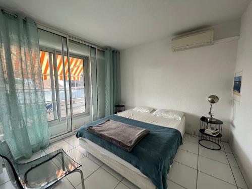 une chambre avec un lit et une grande fenêtre dans l'établissement Appartement T3 Front de Mer avec Terrasse, Parking et Accès Direct Plage au Moulleau - FR-1-374-212, à Arcachon
