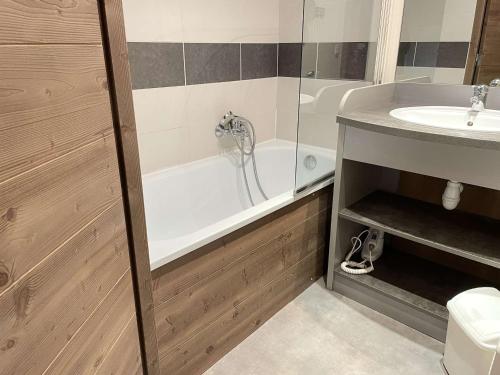 een badkamer met een bad en een wastafel bij Appartement Risoul, 2 pièces, 4 personnes - FR-1-330-563 in Risoul
