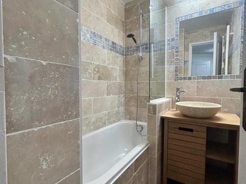 une salle de bain avec un lavabo, une baignoire et un miroir dans l'établissement Appartement 2 pièces avec piscine, parking - 6 couchages à Cannes - FR-1-609-76, à Cannes