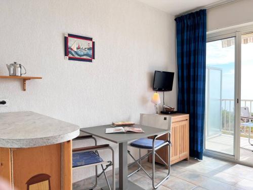 Il comprend un salon avec une table et une cuisine avec un balcon. dans l'établissement Studio cabine 4 pers, climatisé, parking, plage à pied - Le Lavandou - FR-1-251-509, au Lavandou