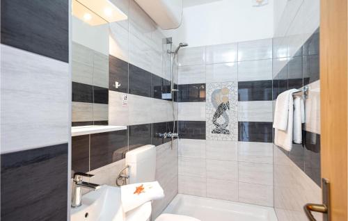 La salle de bains est pourvue d'un lavabo, de toilettes et d'une douche. dans l'établissement Beautiful Home In Krilo Jesenice With Wifi, à Sumpetar