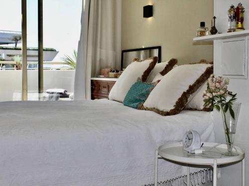 une chambre avec un grand lit blanc et une table dans l'établissement Superbe appartement climatisé avec terrasse et jardin à Villeneuve Loubet Plage - FR-1-252A-106, à Villeneuve-Loubet