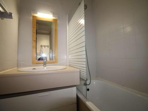 une salle de bain avec un lavabo, un miroir et une baignoire dans l'établissement Studio cabine fermée 4 pers au pied des pistes avec parking - Auris en Oisans - FR-1-297-334, à Auris
