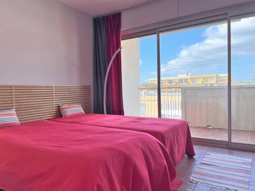 - une chambre avec un grand lit rouge et une grande fenêtre dans l'établissement Appartement climatisé 3 pièces, 6 couchages - Face à la plage - Le Lavandou - FR-1-251-510, au Lavandou