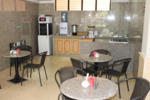 um restaurante com mesas e cadeiras e uma cozinha em Hotel Castellana Inn em Bogotá