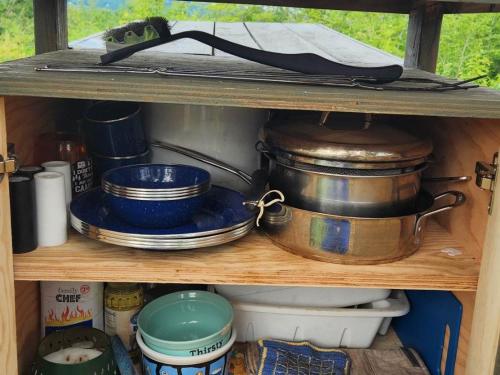 a shelf with many pots and pans on it at Tentrr Signature Site - Mountain View in Buckfield Maine in Paris