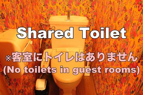 a bathroom with a toilet with the words shared toilet no toilets in guest rooms at Okinawa Minshuku Kariyushi in Shirahama