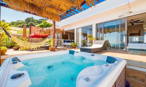 チャウエンノイビーチにあるVilla Jacuzzi Seaview Villaのパティオ(ホットタブ、ハンモック付)