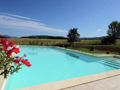 a large blue swimming pool with red flowers at Stunning Farmhouse in Passignano with Pool in Passignano sul Trasimeno