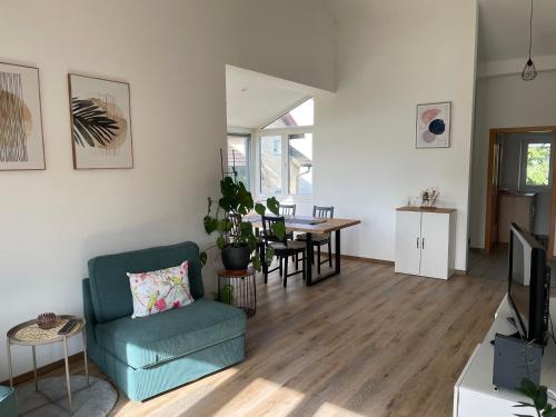 a living room with a blue chair and a table at Ferienwohnung Hofer in Altötting