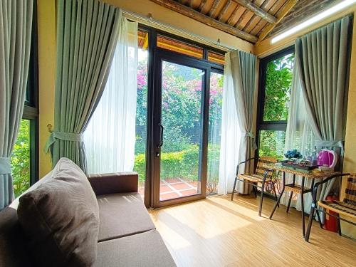 a living room with a couch and a sliding glass door at Tam Coc Sunshine Homestay in Ninh Binh