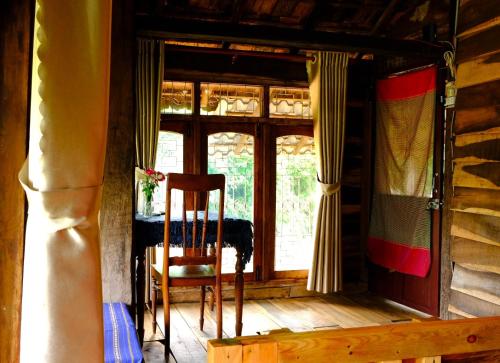 a wooden chair in a room with a window at Plei Homestay & Café in Pleiku