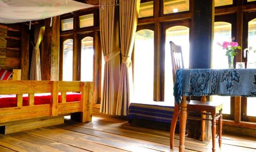 a bedroom with a bed and a table and a chair at Plei Homestay & Café in Pleiku