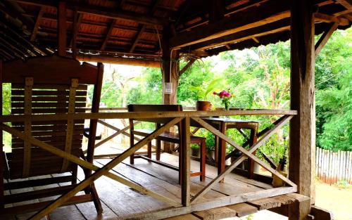 a wooden table in the middle of a porch at Plei Homestay & Café in Pleiku